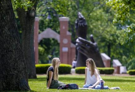 Female students seating in campus lawn